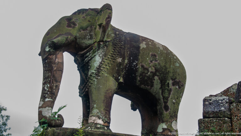Close profile of weathered stone elephant sculpture.
