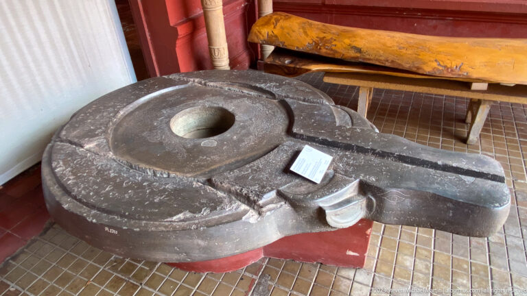 Large circular stone mill or grinder displayed at the National Museum of Cambodia.