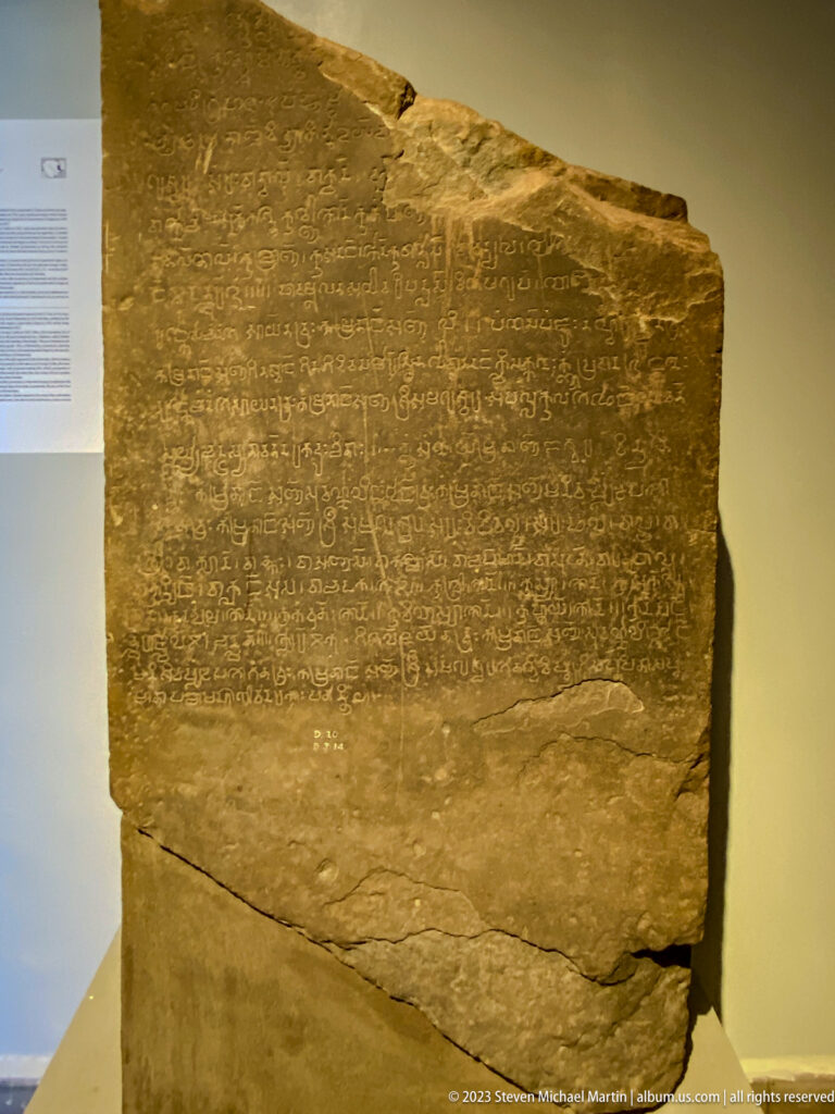 Large fractured stone inscription covered with dense carved lines of ancient script.