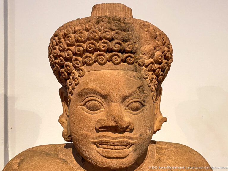 Close view of lion-headed guardian displayed in the National Museum of Cambodia gallery.