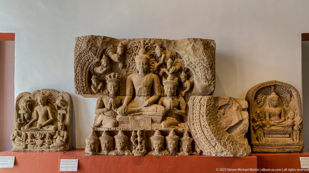 Group of sandstone Buddhist reliefs centered on a seated Buddha with attendants and fragments.