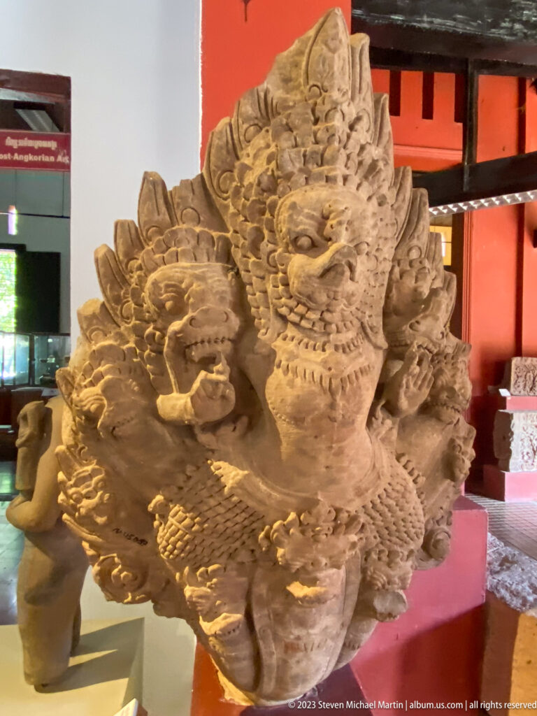 Weathered multi-headed naga with serpent heads radiating outward around a central face.