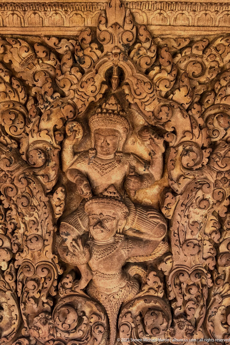 Divine figure in scrolling foliage displayed at the National Museum of Cambodia.
