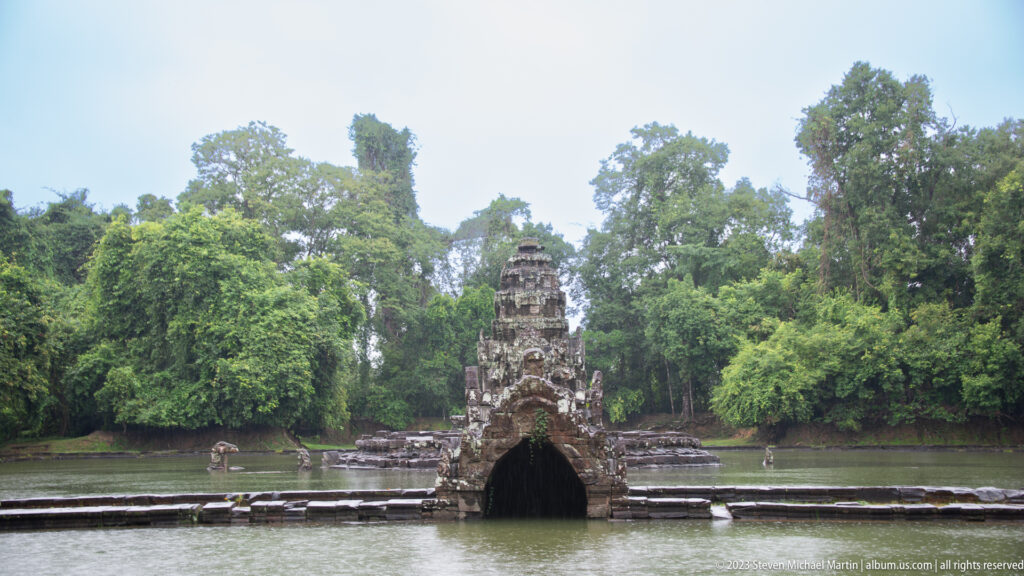 Wide view of Neak Poan sanctuary surrounded by water.