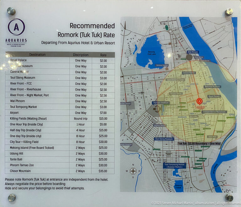 Tuk-tuk fare chart mounted beside a detailed city map of central Phnom Penh.