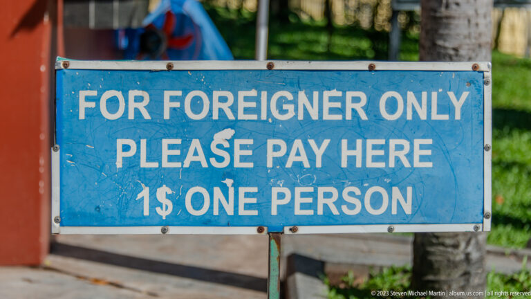 Blue sign reading For Foreigner Only, Please Pay Here, 1 dollar one person.