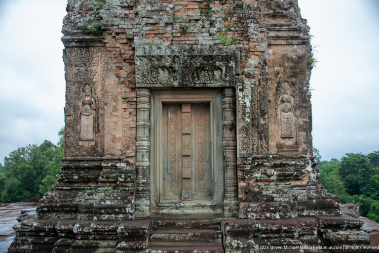 Small weathered brick shrine at Pre Rup with a closed carved stone doorway and short steps.