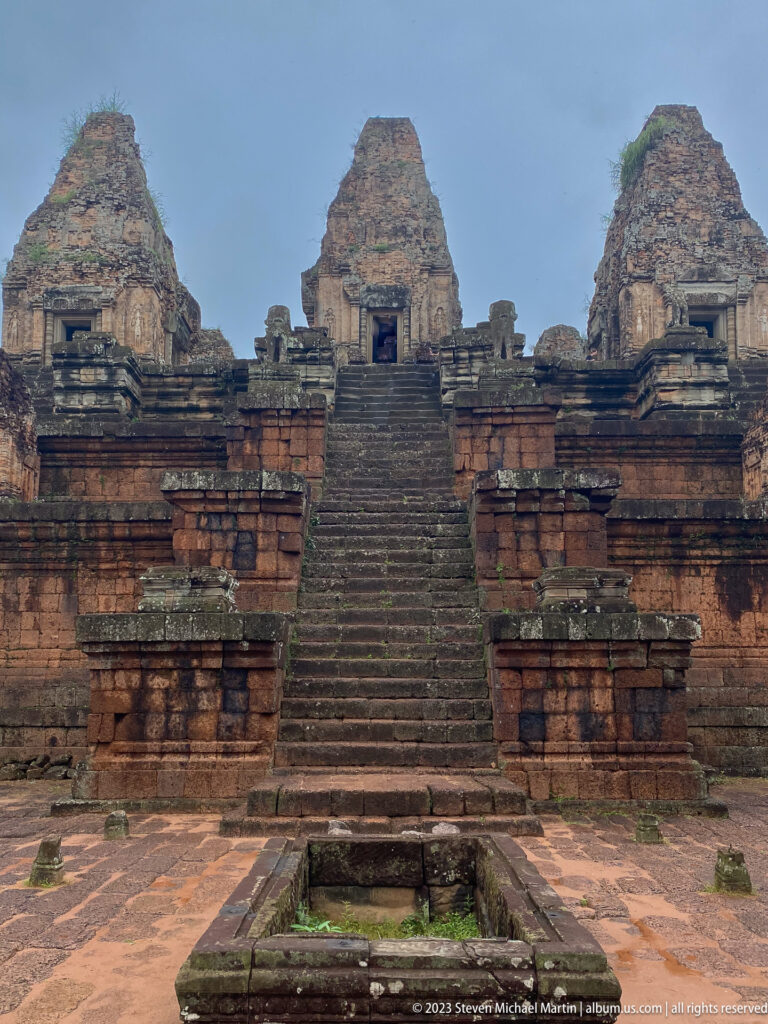 Long central staircase at Pre Rup rising through brick terraces toward three towers.