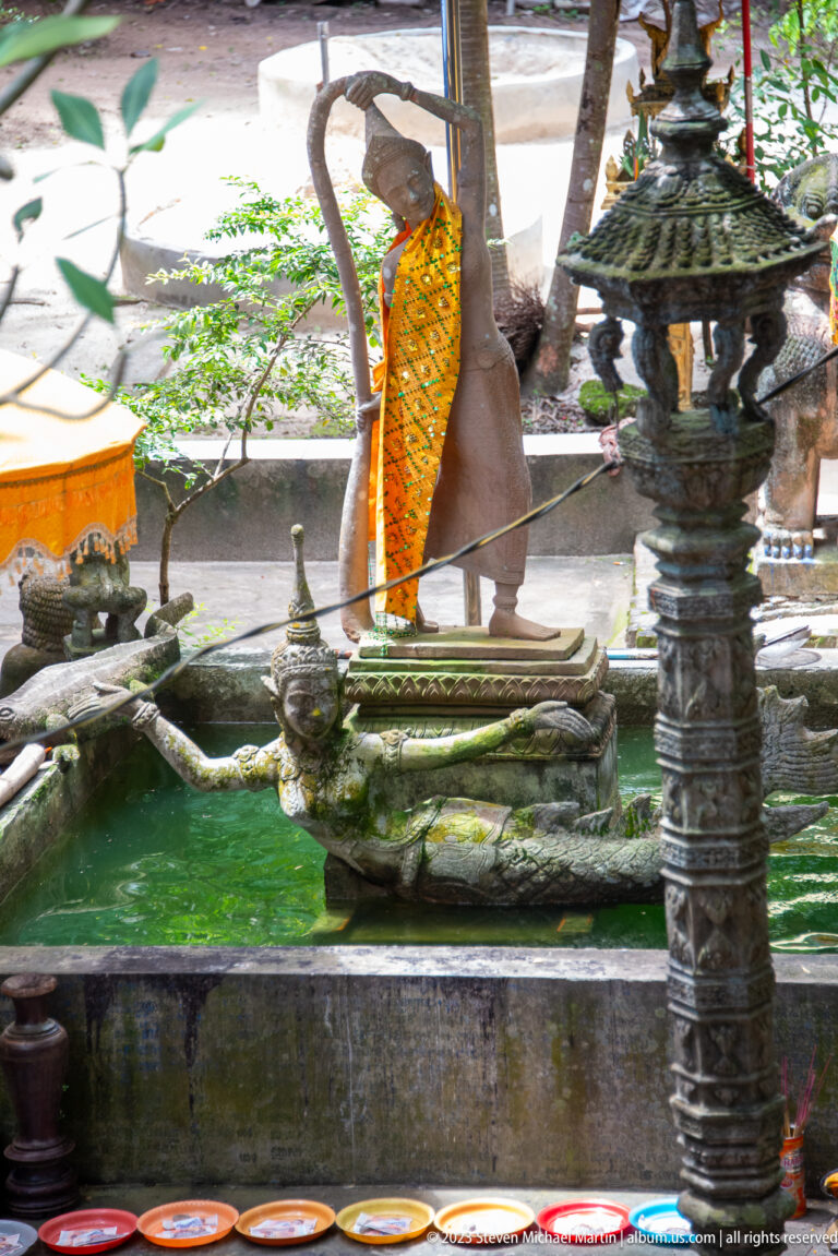 Ornamental green-water basin with bird, serpent, and pedestal sculptures.