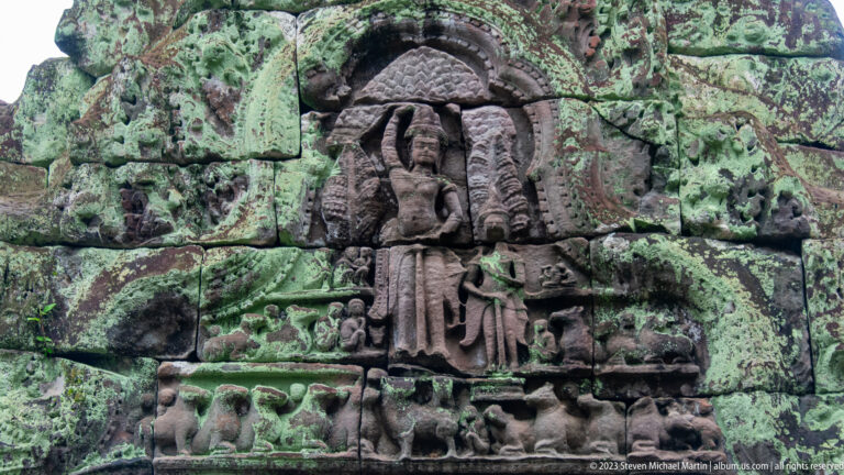 Standing crowned figure beneath a multi-headed naga hood with smaller figures below.