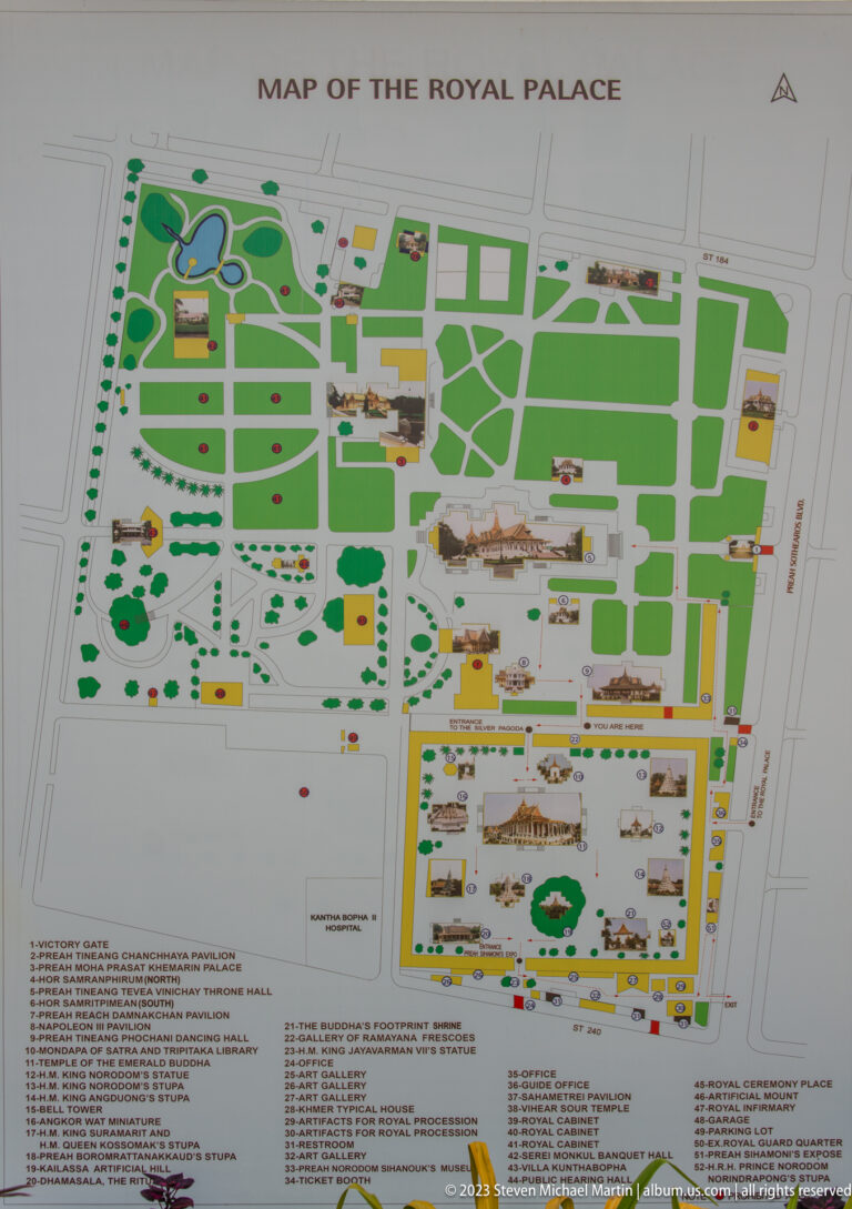 Printed map of the Royal Palace grounds with color-coded buildings, lawns, paths, labels, and numbered sites.