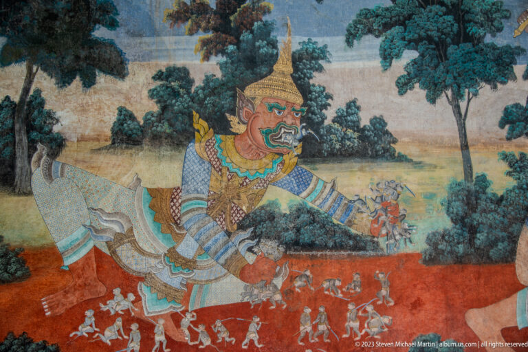 Reamker mural showing a large crowned giant striding above smaller figures in a wooded landscape.