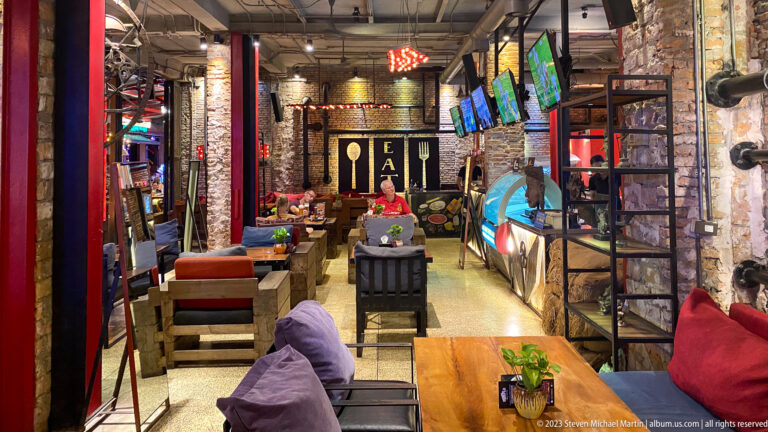 Industrial-style restaurant interior with brick walls and wooden tables.