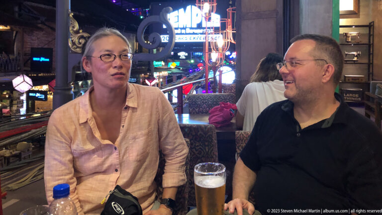 Two people seated with drinks overlooking Pub Street.