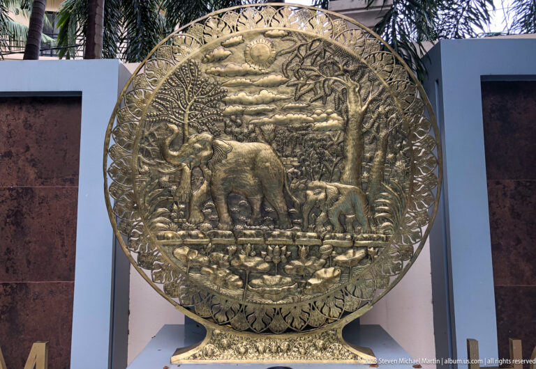 Large circular decorative relief depicting elephants surrounded by tropical foliage.