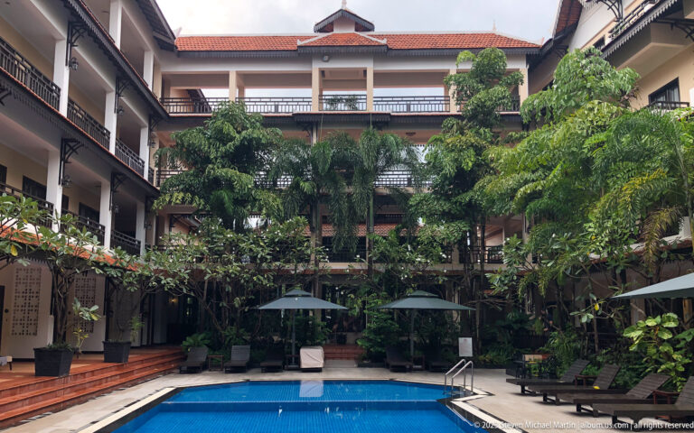 Hotel courtyard with central pool and balconies.