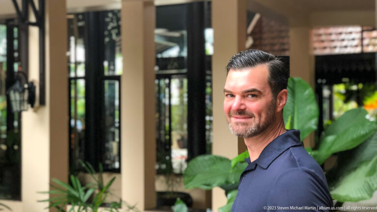 Portrait of visitor with tropical plants behind.