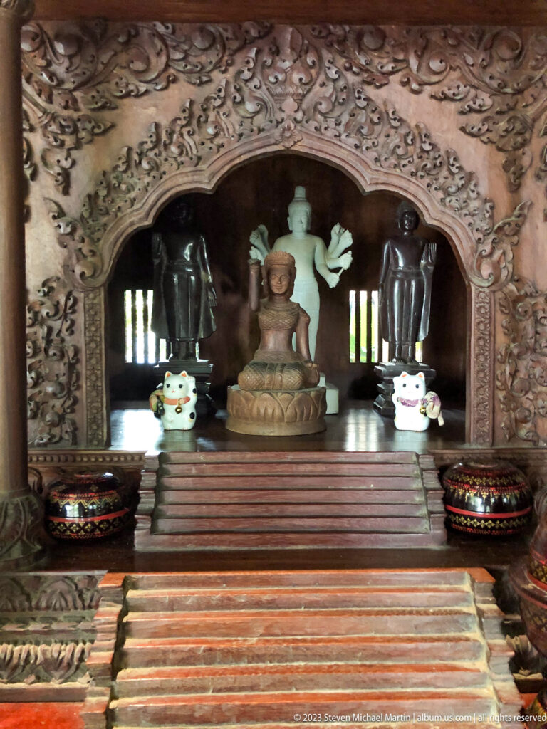 Carved wooden shrine with seated Buddha.