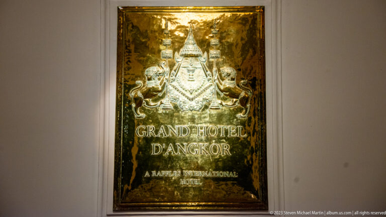 Brass plaque reading Grand Hotel d’Angkor and A Raffles International Hotel beneath an embossed emblem.