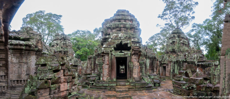Closer frontal view of a central Ta Som tower with dark doorway and weathered stepped masonry.
