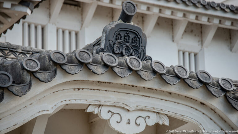 Decorative roof ridge fitting above curved white eaves.
