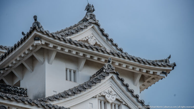 White castle tower corner with layered roofs and ornate gables.