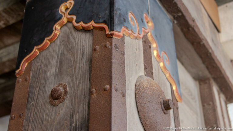 Close-up of a reinforced wooden castle door with iron fittings.