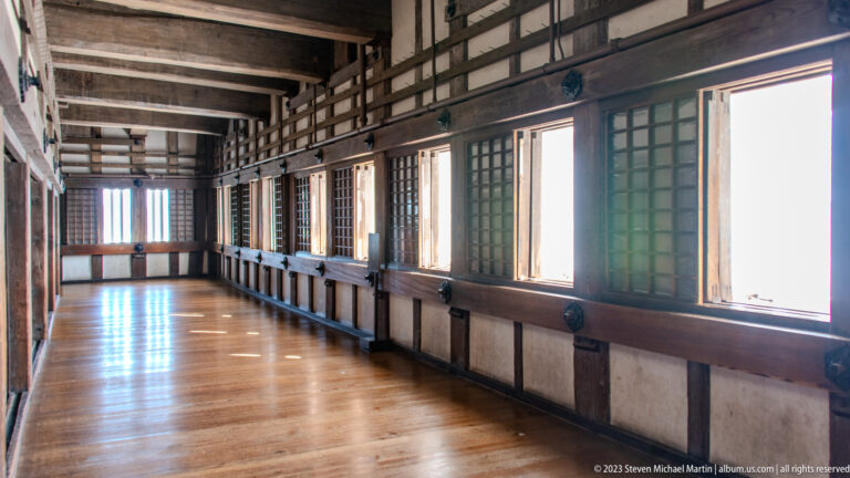 Wooden gallery with rows of windows and polished floor.