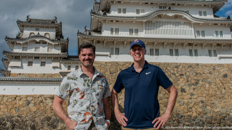Two visitors standing beneath Himeji Castle.