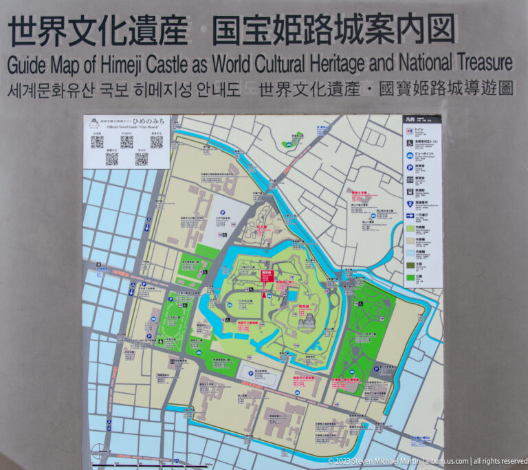 Multilingual Himeji Castle orientation panel with a color map of moats, paths, gates, and inner grounds.
