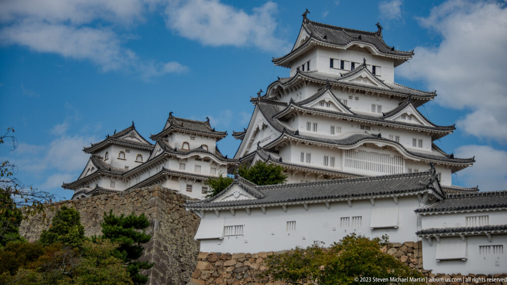Himeji Castle’s white main keep and adjoining towers rising above stone foundations and outer walls.