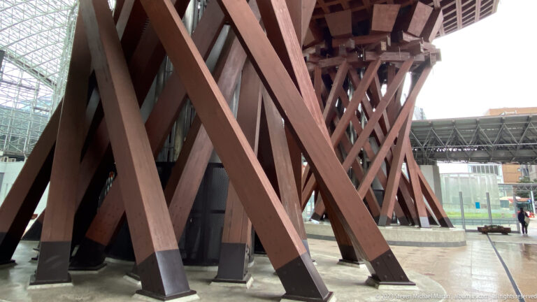 Close view of intersecting timber beams and metal bases supporting Tsuzumi-mon Gate.