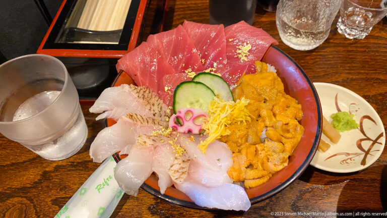 Seafood rice bowl topped with tuna, white fish, sea urchin, cucumber, and lotus root.