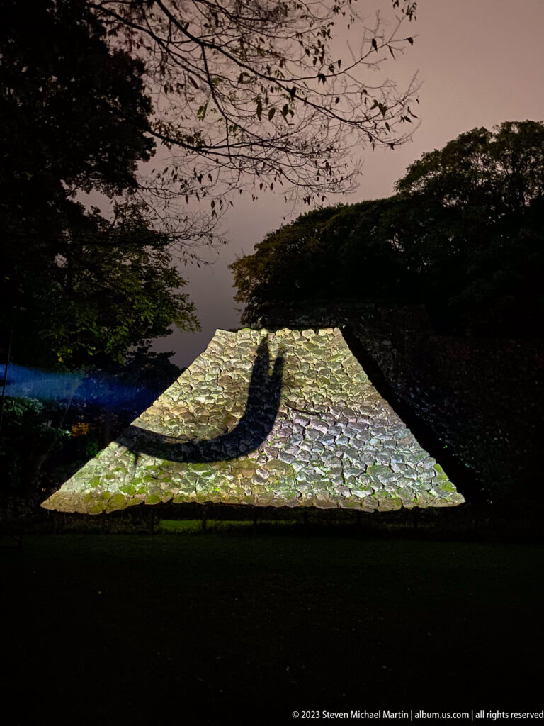 TeamLab’s luminous Zen ensō projected across an old stone wall at Kanazawa Castle.