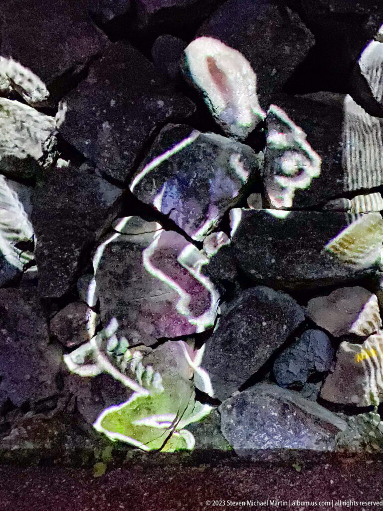 Large stylized running figure projected across irregular paving stones.