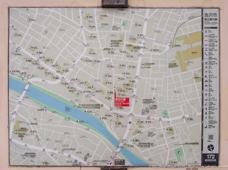 Detailed public street map of central Kanazawa with river, roads, landmarks, and a red location marker.