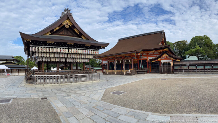 Lantern-covered Buden dance stage and vermilion buildings in the courtyard of Yasaka Shrine.