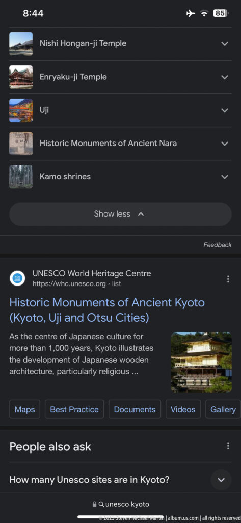 Phone displaying UNESCO Ancient Kyoto information in its surrounding Kyoto setting.