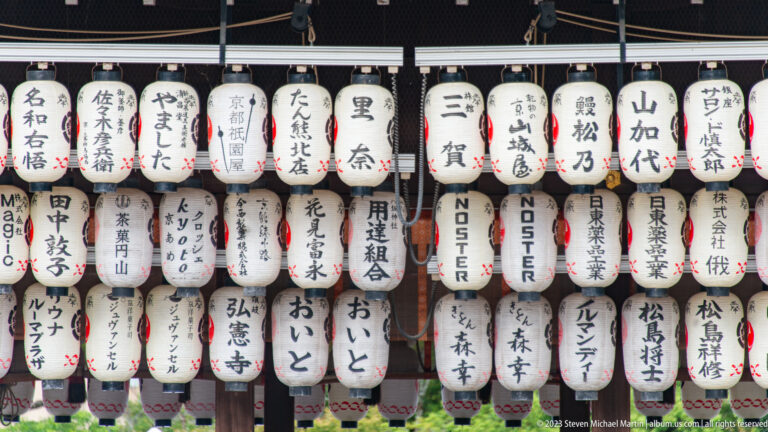 Rows of white paper lanterns with black Japanese inscriptions hanging from the Buden.
