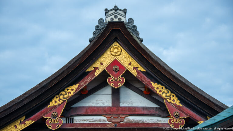 Close view of an ornate shrine gable with gilded carved decoration.