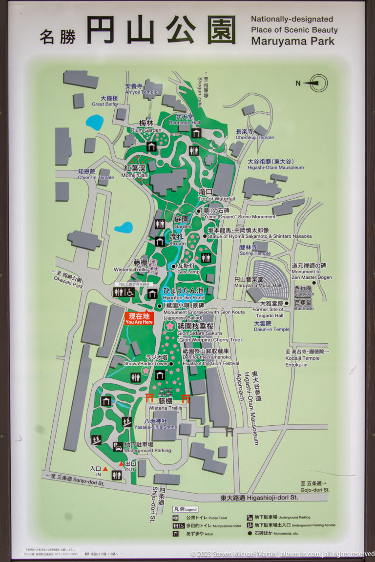 Bilingual map of Maruyama Park showing paths, ponds, buildings, and surrounding streets.