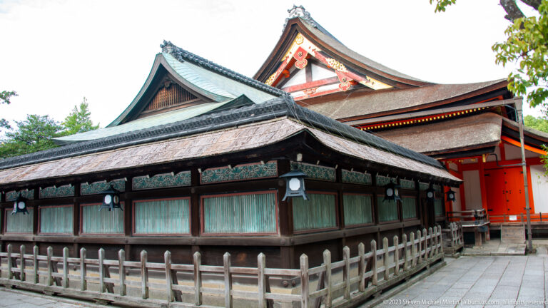 Side view of connected wooden halls with broad traditional roofs at Yasaka Shrine.