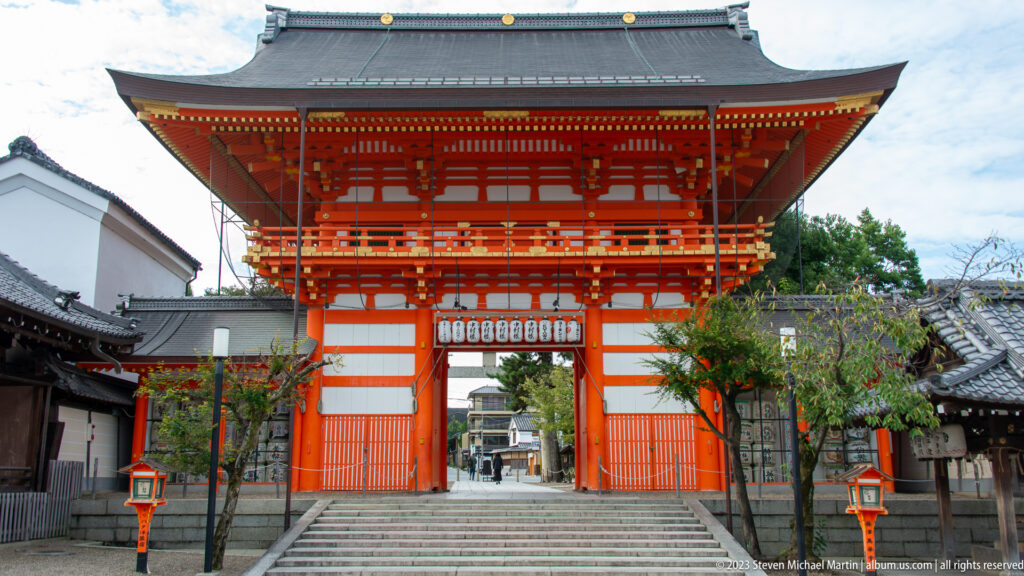 Large vermilion shrine gate standing above broad stone steps.