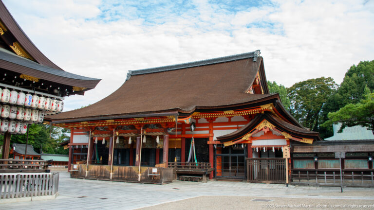 Wide view of Yasaka Shrine’s main halls and lantern-covered ceremonial stage.