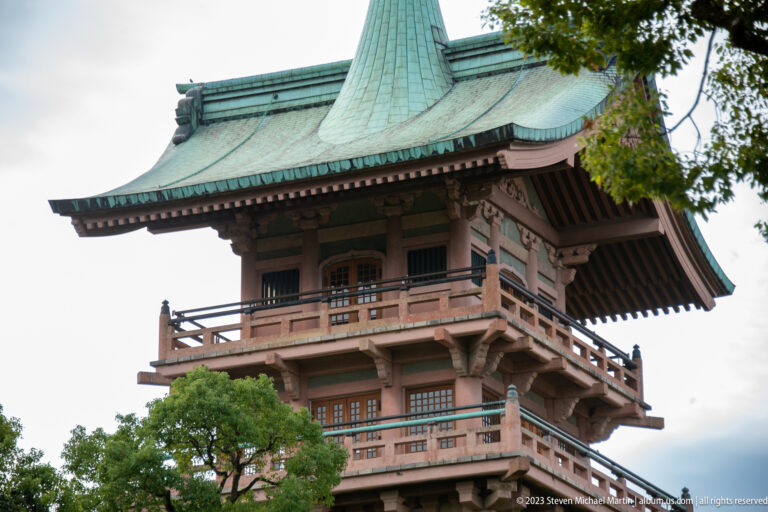 Upper wooden stories of Gionkaku with green copper roof and tall spire.