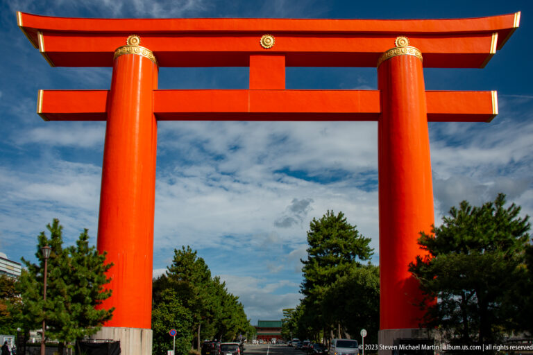 Close frontal view of Heian Jingu’s monumental vermilion Otorii above Jingu-michi in its surrounding Kyoto setting.