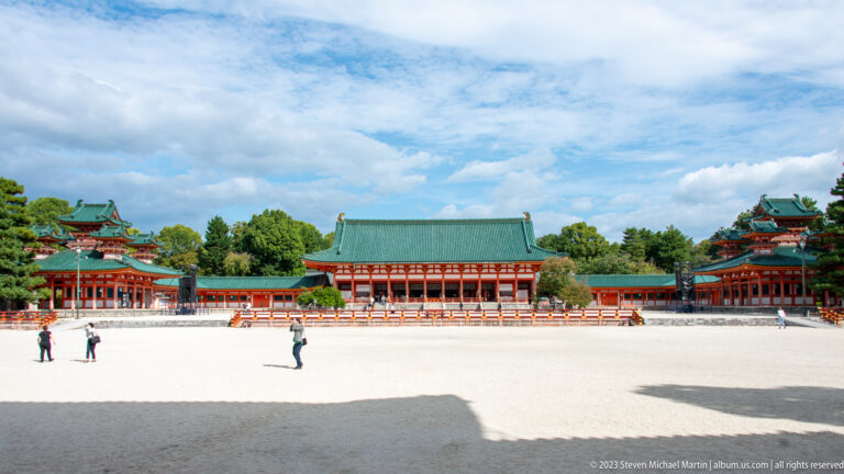 Wide gravel courtyard at Heian Jingu with the Daigokuden centered between vermilion buildings.