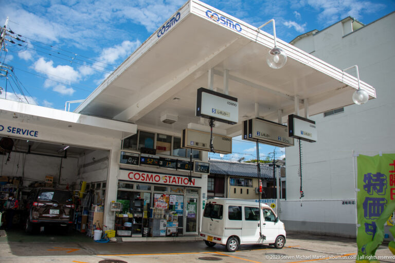 Cosmo gasoline station with pumps and service bays in its surrounding Kyoto setting.