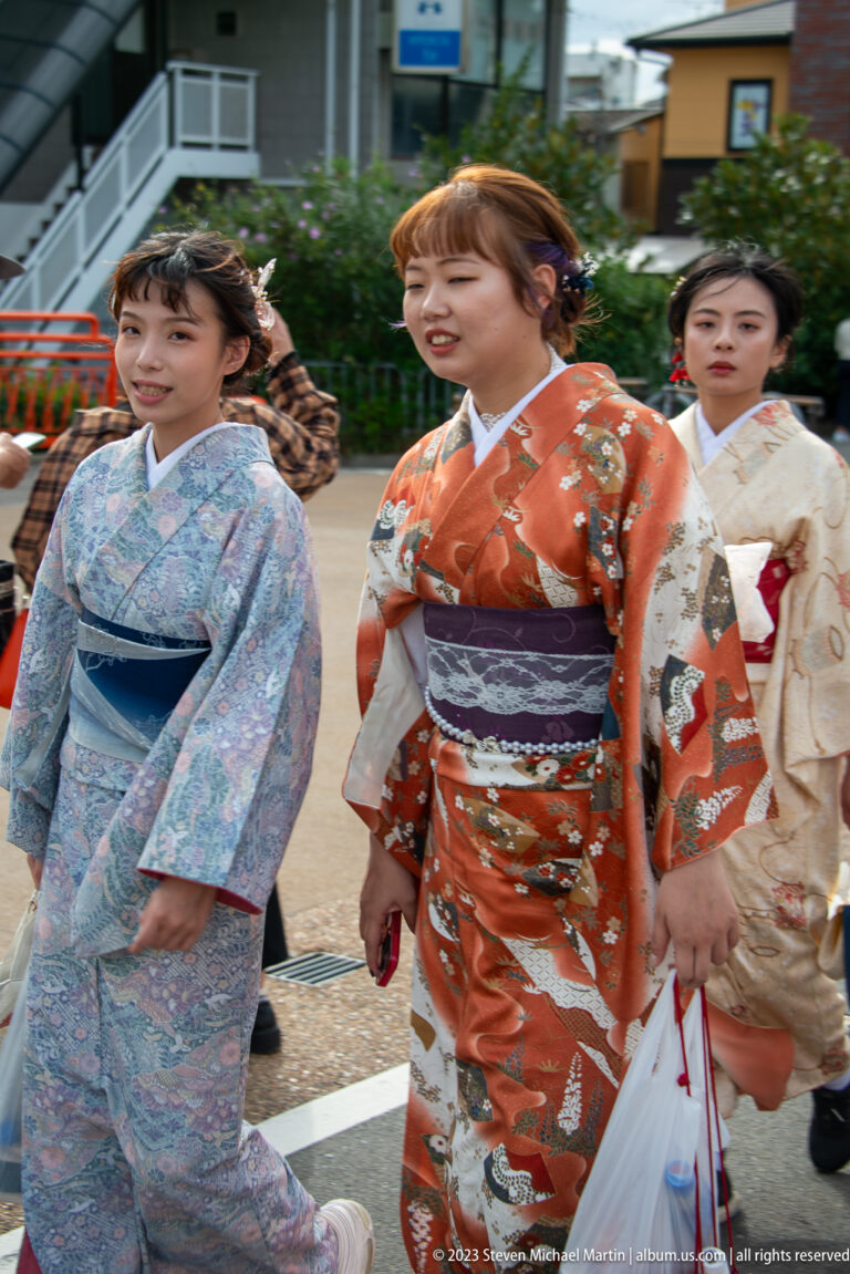 Women in colorful kimono walking in its surrounding Kyoto setting.