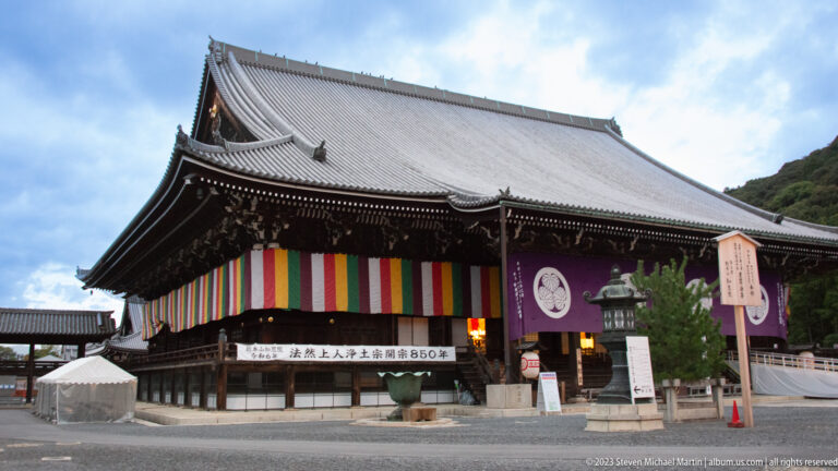Large Chion-in hall with tiled roof, five-colored hangings, purple crested curtain, and an anniversary banner.